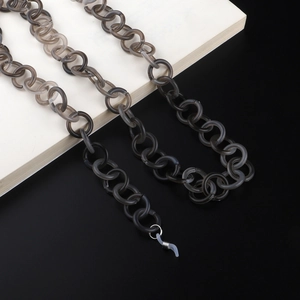 Détail de maillons en acrylique gris translucide avec boucles en silicone antidérapantes