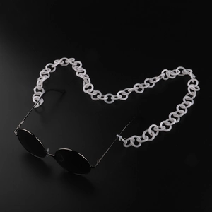 Détail d'un cordon de lunettes en acrylique blanc sur lunettes de soleil rondes