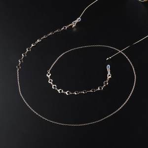 Golden round link eyewear chain and necklace with silicone loops on black mirror