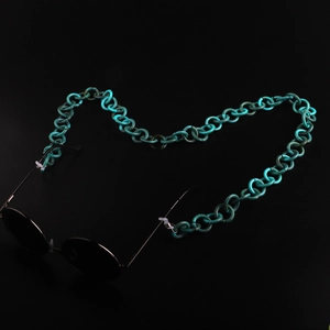 Chaîne de lunettes en acrylique marbre vert avec motif écaille sur fond noir élégant