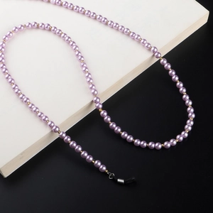 Detail of lavender pearl eyeglass chain with gold beads and black rubber connectors