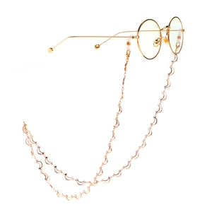 Minimalist gold moon chain eyewear accessory with circular glasses on white backdrop