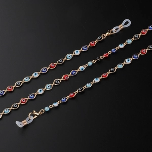 Handmade evil eye glasses chain with colorful beads and golden metal links on black background