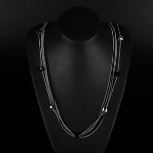 Collier multicouche argenté avec perles de cristal noir exposé sur un buste de bijoux