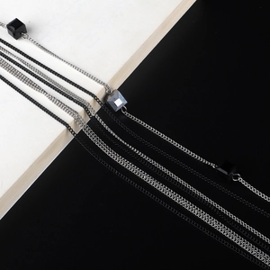 Collier multicouche argent et noir avec perles cubes géométriques sur un fond de livre chic