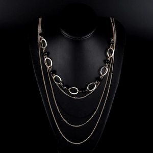 Elegant layered gold chain necklace featuring black crystal beads and oval metal rings