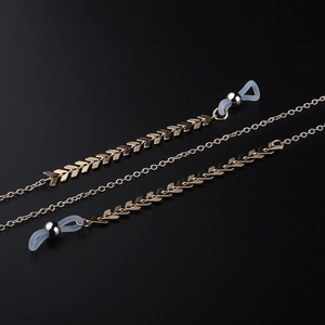 Handmade gold copper airplane bead glasses chain with arrow links on a dark background