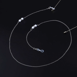 Dettaglio catenella per occhiali argento con perle bianche, strass e ganci in silicone