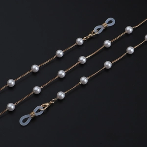 Elegante goldene Brillenkette mit 8mm weißen Perlen auf schwarzem Hintergrund