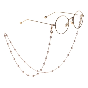 Elegante goldene runde Brille mit weißer Kunstperlenkette auf weißem Hintergrund