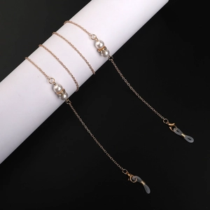 Dettaglio catena per occhiali dorata con perle bianche, strass e anelli in silicone