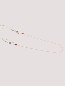 Detail of golden glasses chain with seashell charms, red and cyan beads on snake chain