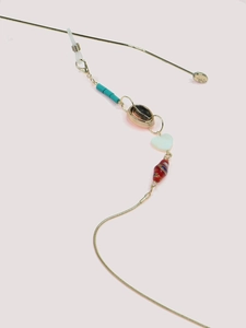Detail of bohemian gold snake chain glasses strap with turquoise beads and shell charms