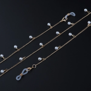 Détail de la chaîne de lunettes dorée avec perles blanches et boucles en silicone