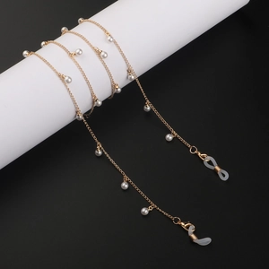 Détail de la chaîne à lunettes dorée avec perles blanches et boucles en silicone