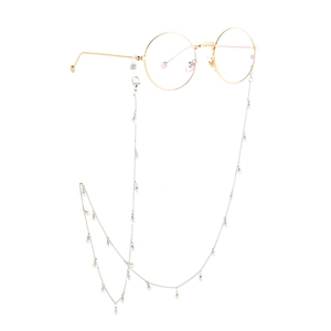 Lunettes rondes dorées élégantes avec chaîne de perles faite main sur fond blanc