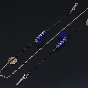 Détail d'une chaîne à lunettes faite main avec fleurs bleues et maillons dorés