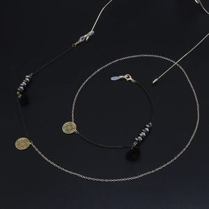 Détail de la chaîne de lunettes à fleurs colorées avec maillons dorés noirs et petits glands