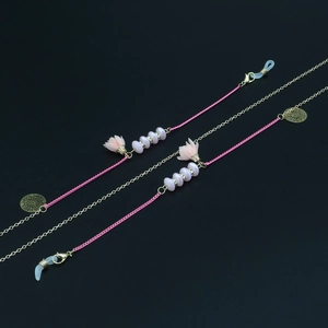 Détail de la chaîne à lunettes avec perles de fleurs roses et fermoir doré