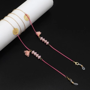 Détails de fleurs en mousseline rose et perles dorées sur la chaîne de lunettes bohème