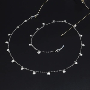 Silver chain glasses strap with shell pendants and silicone loops on black background