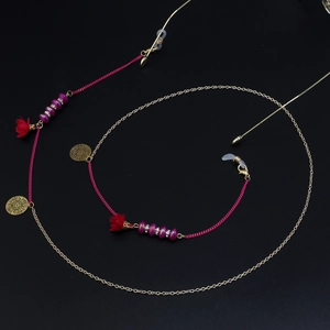 Détail de la chaîne de lunettes avec perles fleuries, maillons dorés et pompons roses