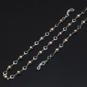 Silver metal eyewear chain with coffee and white evil eye beads on black background