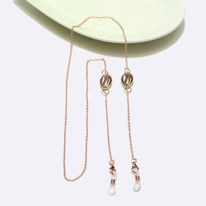 Chaîne de lunettes dorée avec breloques coquillage sur fond blanc et platine
