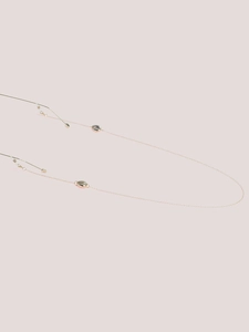 Gros plan d'une chaîne de lunettes dorée avec pendentifs coquillages et boucles