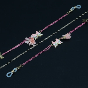 Détail macro d'une chaîne de lunettes avec fleurs en tulle rose et papillons en émail