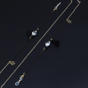 Close-up of multicolor ceramic beads, tassels, and gold flower charms on the eyewear chain