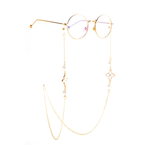 Golden metal eyeglass chain with white pearls and flower pendants on round glasses