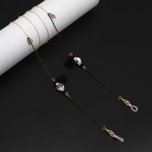Detail of beaded eyewear chain with gold butterfly charms, black tassels and ceramic beads