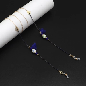 Detail of beaded eyewear chain with Hamsa Hand charm and blue tassels on metal links