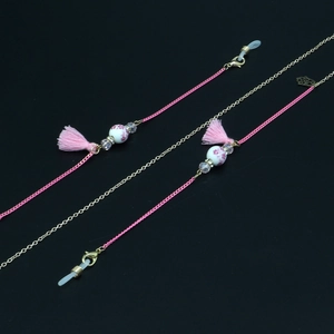 Detail of pink woven rope glasses chain with ceramic floral beads and silk tassels