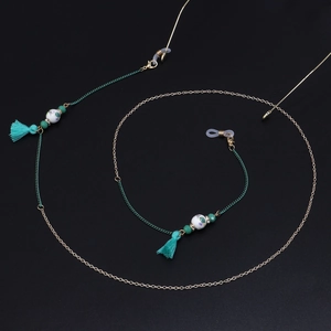 Detail of colorful ceramic beads and turquoise tassels on a gold metal eyeglass chain