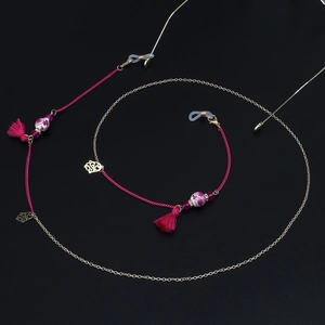 Detail of bohemian eyewear chain with ceramic beads, pink tassels and golden links