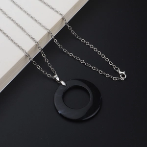 Minimalist silver chain necklace featuring a large round black marble texture pendant