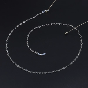 Chaîne à lunettes argentée avec trèfles et boucles en silicone sur fond noir