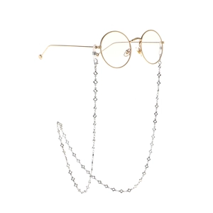 Lunettes rondes dorées avec une chaîne en métal décorative aux motifs de fleurs