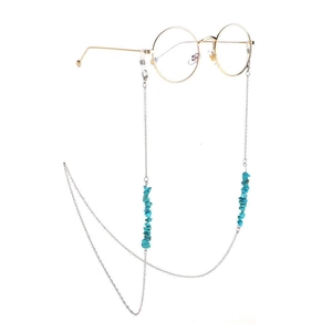 Golden metal eyewear chain with turquoise stone beads on glasses against white background