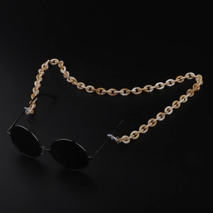 Detail of a two-tone amber and white acrylic eyeglass chain on retro sunglasses