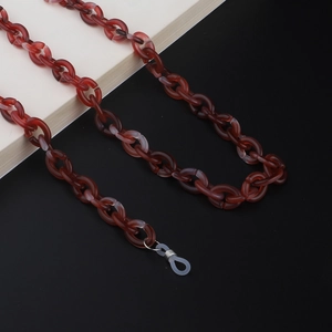 Close-up of amber acrylic eyeglass chain with tortoiseshell texture and non-slip silicone loops