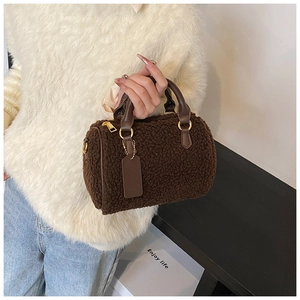 Dettaglio borsa Boston in lana d'agnello marrone scuro con manici in pelle e zip dorate