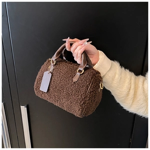 Dettaglio borsa a cilindro in lana di agnello marrone con finiture in ecopelle marrone