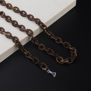 Close-up of tortoise shell acrylic eyeglass chain with silver lobster clasp and silicone loop