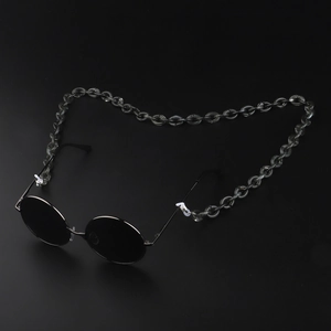 Close-up of translucent grey acrylic chain links on round metal sunglasses