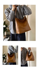 Detail of caramel brown leather hobo bag with vertical stitching and wide shoulder strap