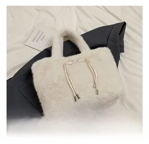 Détail d'un sac cabas en fausse fourrure blanche avec un nœud décoratif en soie