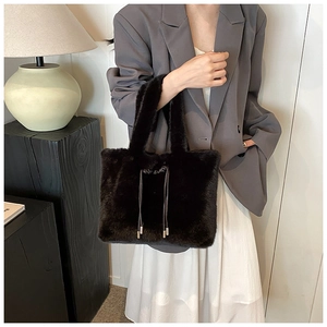 Détail d'un sac cabas noir en fausse fourrure avec cordon tenu par un mannequin